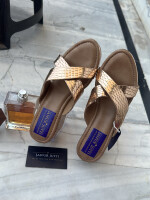 A pair of rose gold toned glossy finish open toe heels by Inayat