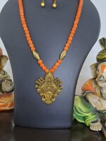 Orange glass beads necklace with oxidised golden Durga pendant and matching earrings