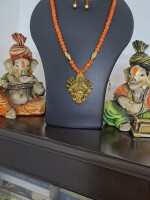 Orange glass beads necklace with oxidised golden Durga pendant and matching earrings