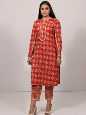 Straight-cut red cotton printed kurta with an elegant flowing lace pattern on the sleeve and yoke line, paired with matching printed cotton pants