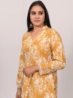 A-line cotton mustard floral printed kurta with a center button line pattern and multilayered lace sleeves, paired with Leheriya cotton pants,