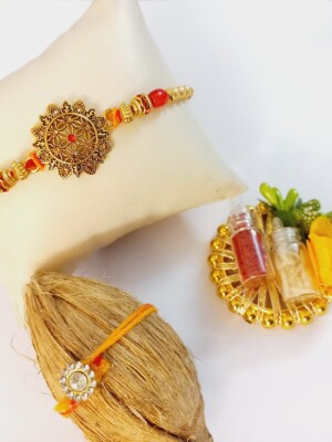 Beautiful golden rakhi for bhai with mini nariyal roli and chawal