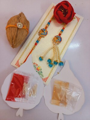 Gleaming blue and gold rakhi set for bhai and bhabhi