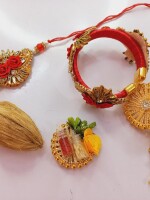 Elegant kundan pair rakhi set for bhai and bhabhi with mini nariyal, roli, and chawal